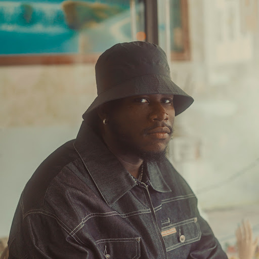 Portrait of artist in a bucket hat and denim jacket.