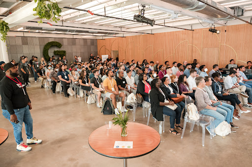 Large group of attendees sitting down and watching a presentation off screen