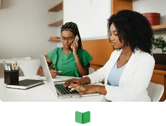 One woman is on the phone while taking notes and another is on her laptop working.