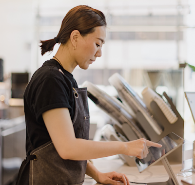 Coffee shop employee tapping on a tablet.