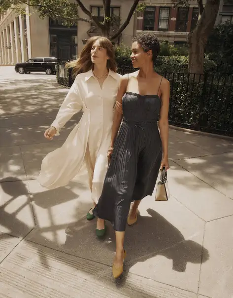 Dos mujeres andando por una zona metropolitana por la tarde.