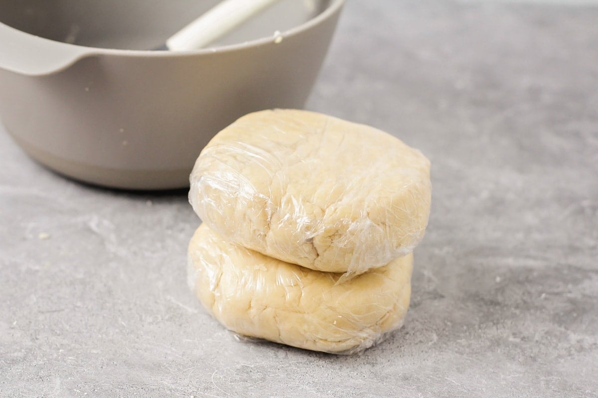 Wrapping pie dough into two discs.