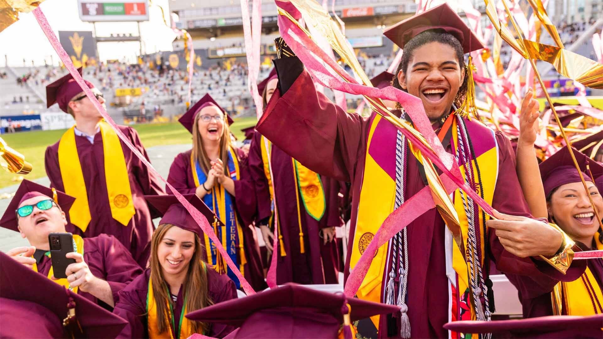 A group of graduates from Arizona State University celebrate at commencement.