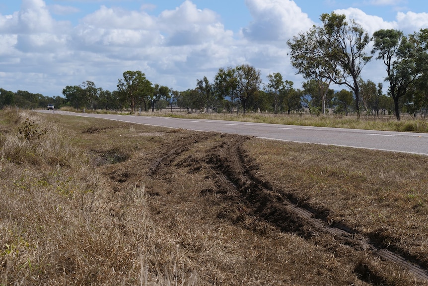 Muddy tyre tracks coming off a highway.