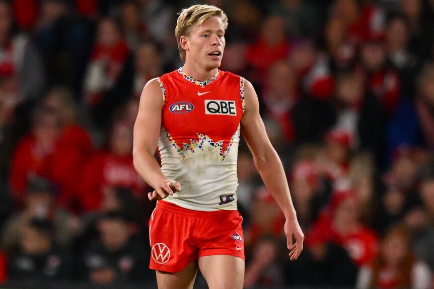 Isaac Heeney walking along the Docklands pitch during an AFL match.