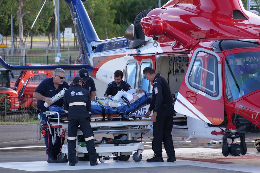 A person is stretchered out of a helicopter.