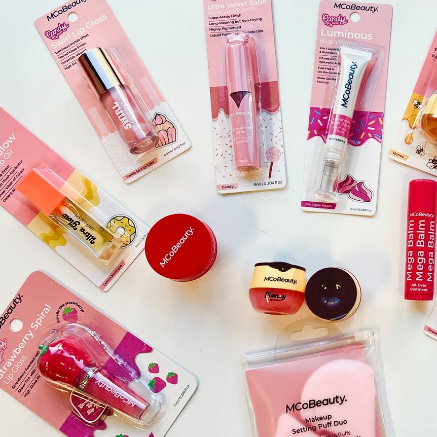 An overhead shot of pink cosmetics against a white background.