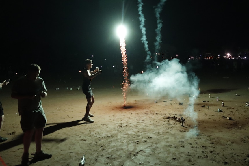 People letting off fireworks on a beach