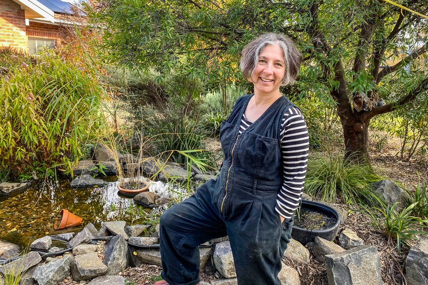 Sarah stands in front of a small pond