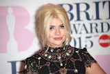 A woman on a red carpet with a black and red sparkly dress 