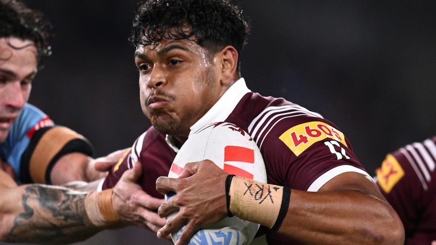 Selwyn Cobbo of the Maroons fends off Nicho Hynes of the Blues during State of Origin