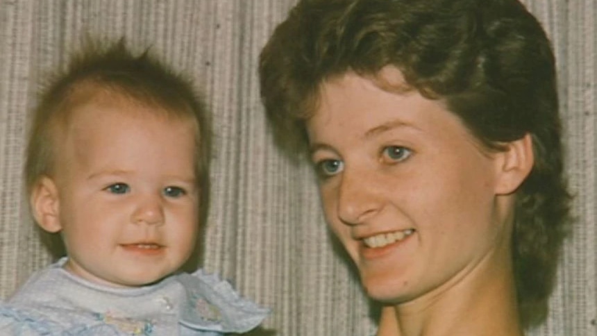 An old photo of a young woman holding a smiling baby.