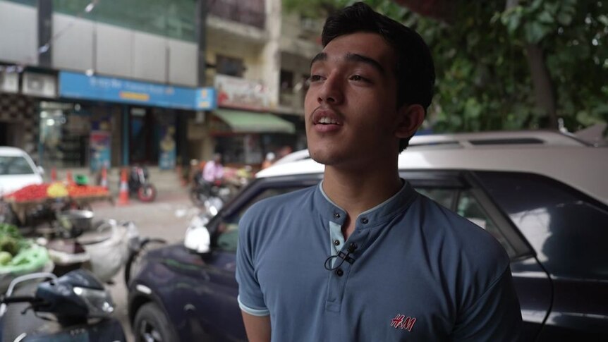 Youngman wearing blue t-shirt speaking during a street interview.