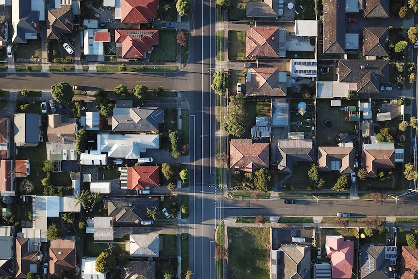 Drone view of housing rooftops and roads