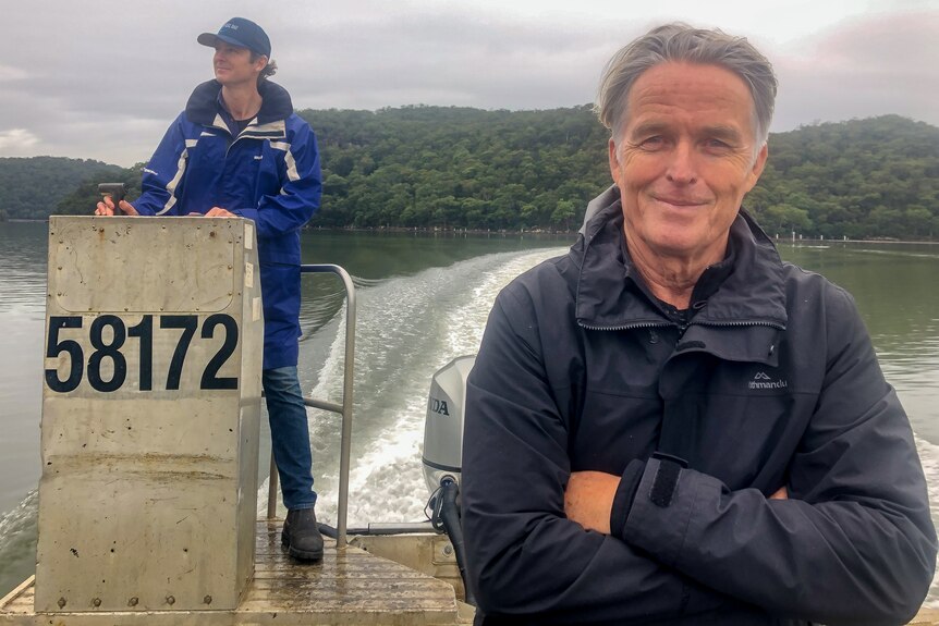 Male reporter and boat captain on boat on river