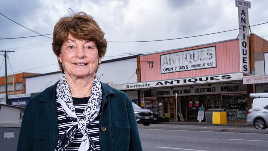 A woman next to an antiques store