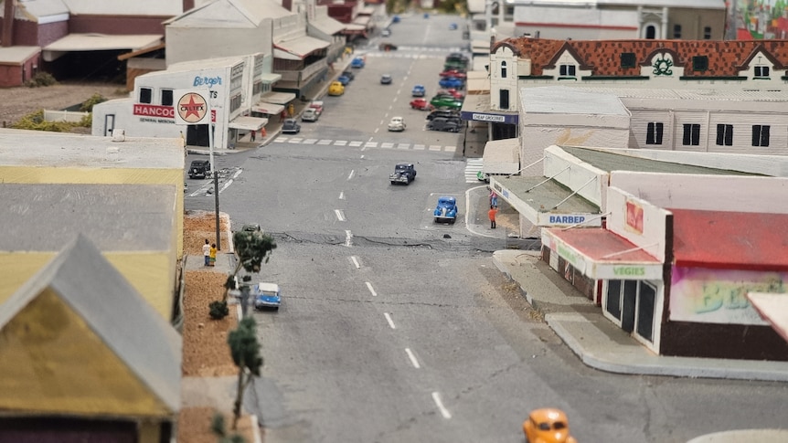 Replica of a main street with cars and businesses on both sides.