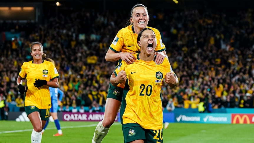 Two female footballers celebrating after a game win 