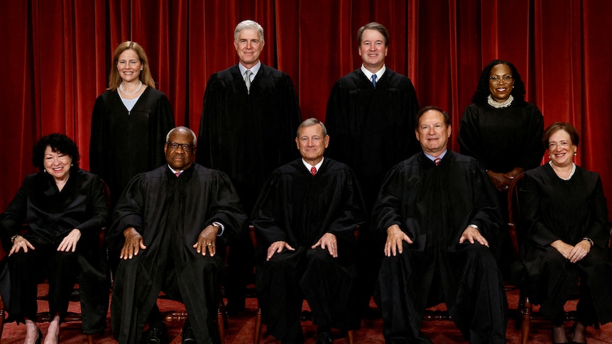 Supreme Court justices sitting and standing in black robes in official portrait.