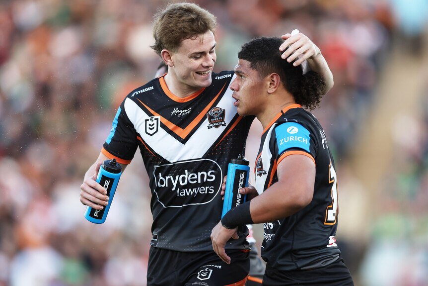 Luke Laulilii celebrates with Wests Tigers NRL teammate Lachlan Galvin after scoring a try.