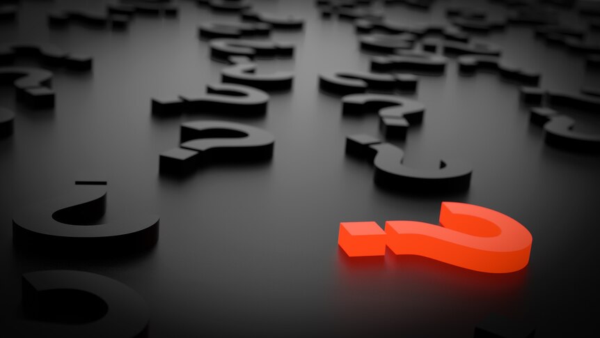 Letters lying on a black background with a red question mark in the foreground.