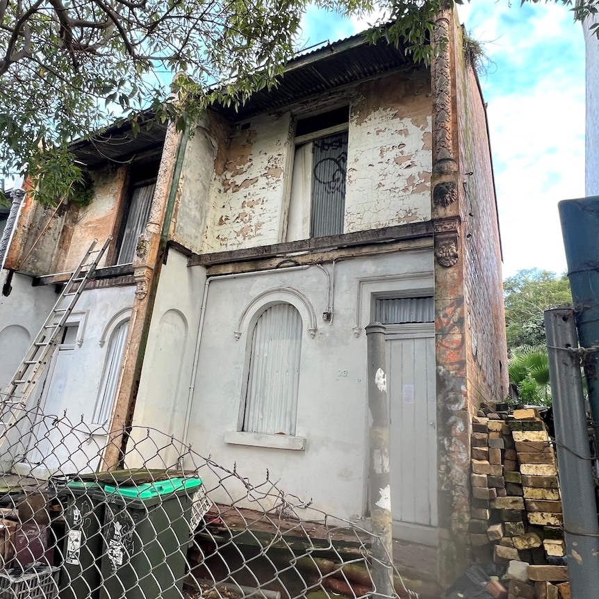 Derelict terrace houses sit empty and boarded up.