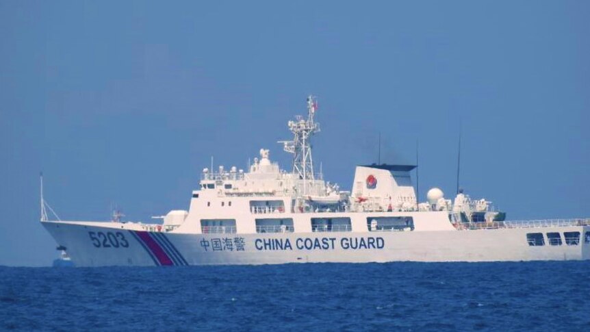 A Chinese coast guard ship is seen in the distance in the South China Sea.  