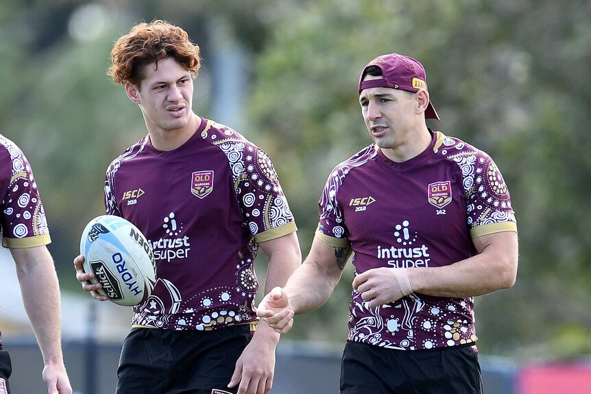 Kalyn Ponga looks on, as Billy Slater speaks at a Queensland State of Origin training session.