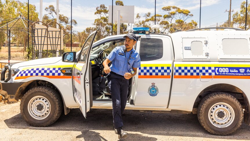 young police officer stepping out of a police van