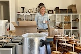 A smiling woman standing in front of a table of candles