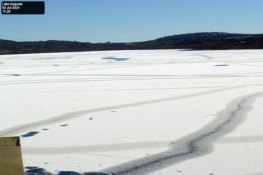 A lake frozen over on a clear day.