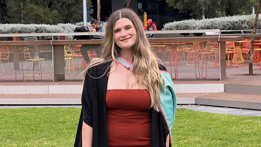 A woman in a dress at her graduation. 