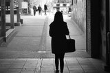 Woman in shadow walking down a tunnel.