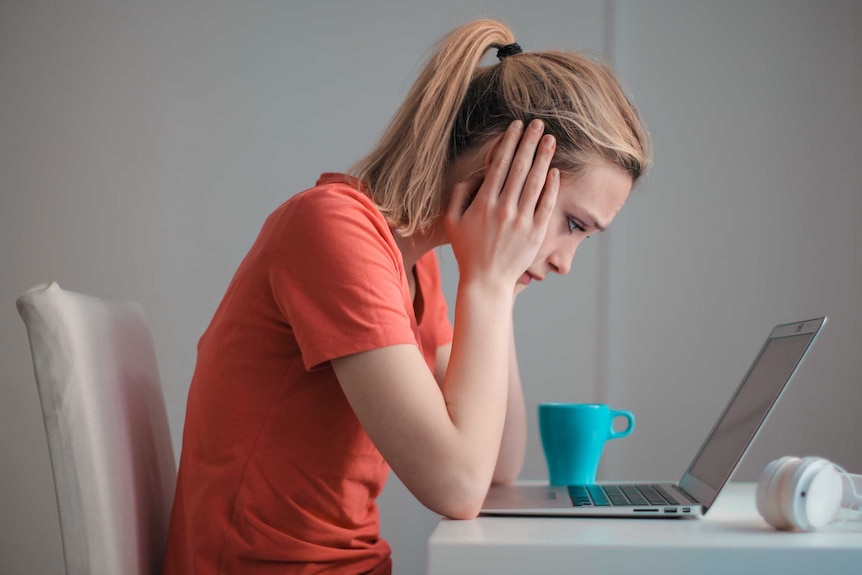 Woman looks at laptop screen, for a story about energy bill shock.