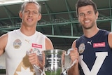 Nat Fyfe and Trent Cotchin smile while holding a big silver trophy between them.