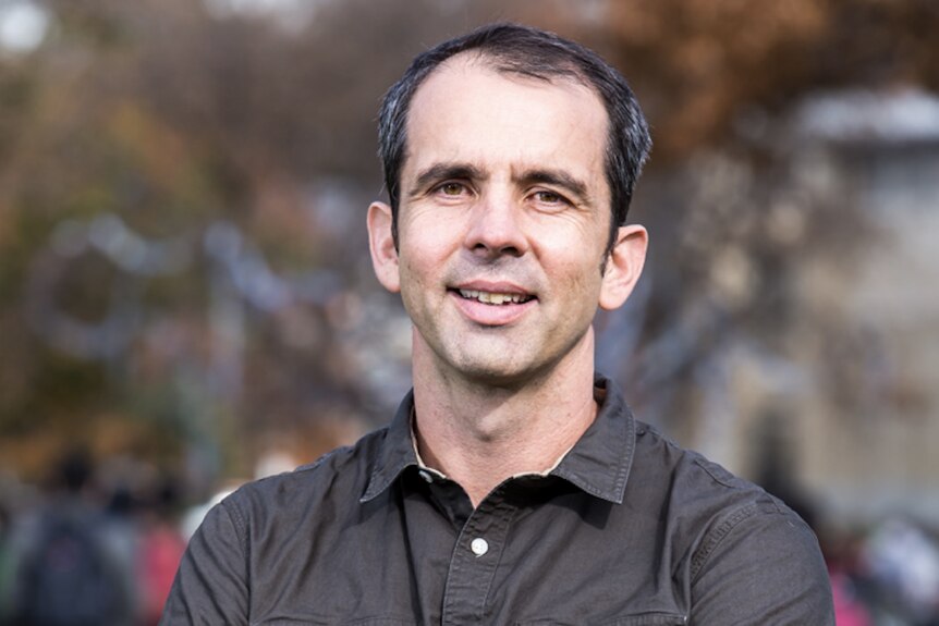 Headshot of Prof Simon Lucey, who is staring at the camera wearing a brown shirt.