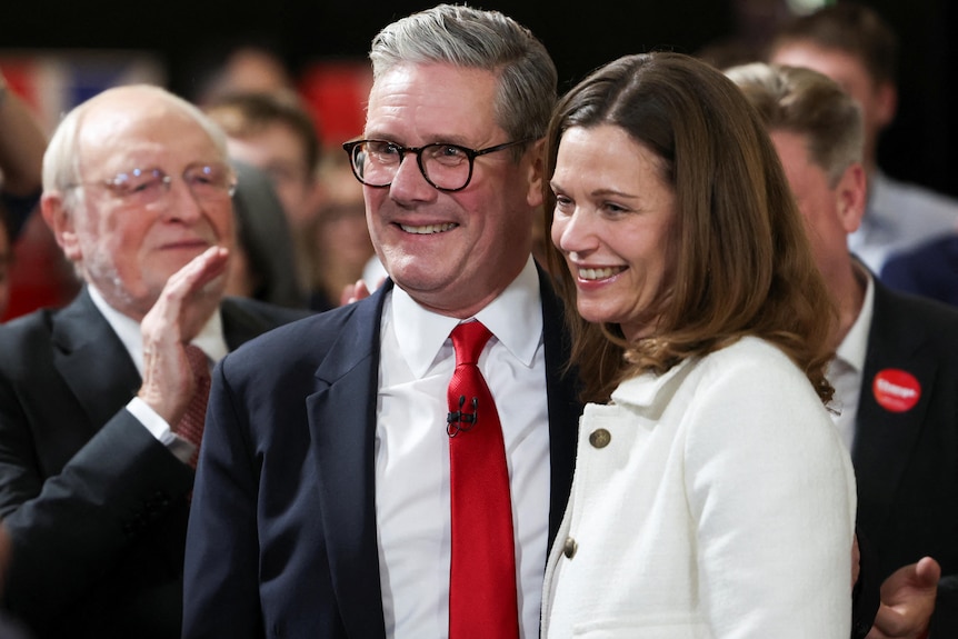 Keir Starmer and a woman smiling in a crowd. 