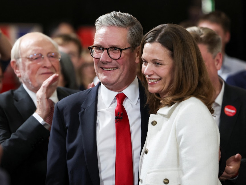 Keir Starmer and a woman smiling in a crowd. 