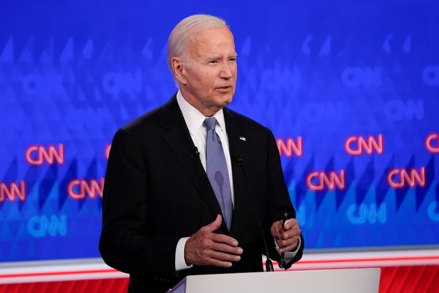 Joe Biden gestures with both hands as he speaks from behind a lectern during a studio debate.