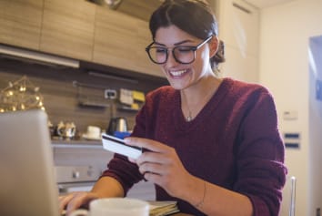 Woman shopping online with a gift card 