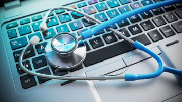 doctor's stethoscope sitting on computer keypad