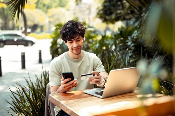 Person shopping online while seated outside.