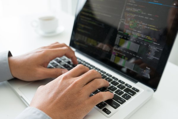 A close-up of someone typing on a laptop