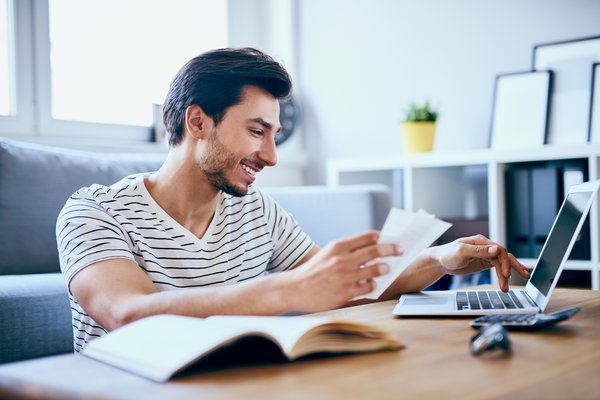 Person paying bills online from laptop.