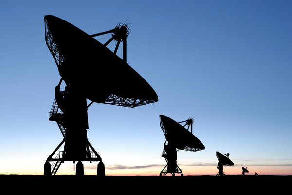 Satellite dishes pointed at the sky at dawn.