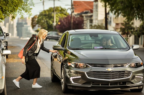 A rider entering a Lyft vehicle.