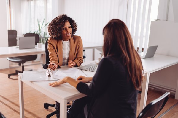 Financial advisor sitting at desk and reviewing documents with client