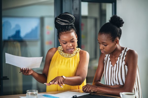 Two co-workers discussing a document.