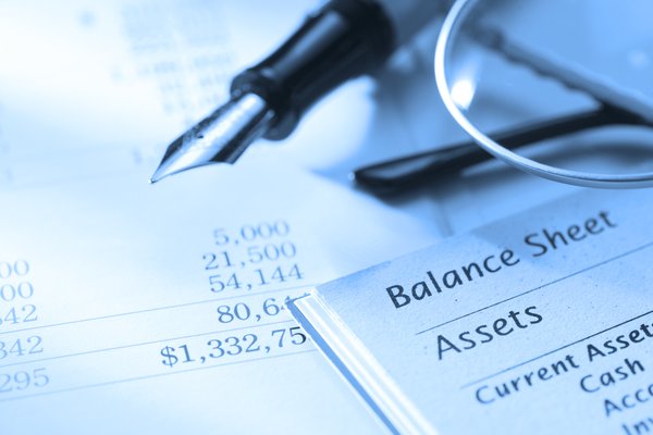 Balance sheet with a fountain pen and glasses lying on top.