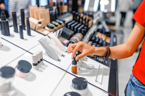 Person browsing cosmetics section at a department store.